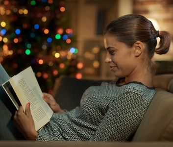Woman reading book at Christmas