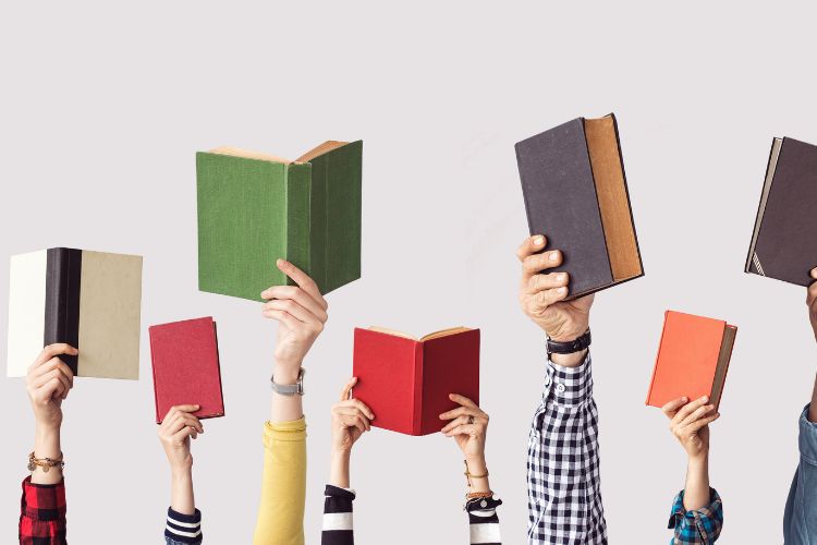 Hands with books in the air